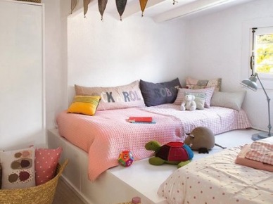 Dziecięce łóżka na białym podeście,kolorowe proporczyki ,różowy taboret z sizalowym siedziskiem,kosz z liści bambusa,kolorowe poduszki w pokoju dla dziecka (26437)
