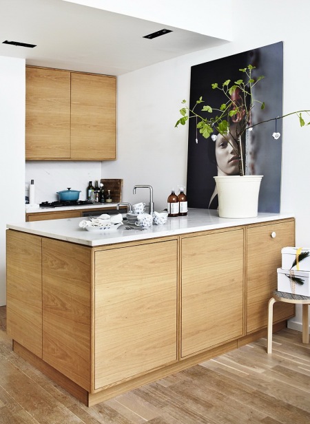 Minimalisryczna kuchnią z drewna  z czarną nowoczesna fotografią na ścianie
