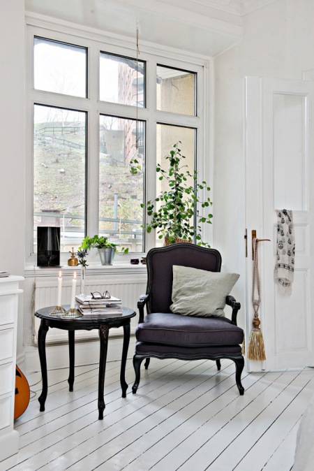 Niski stolik okrągły w stylu ludwikowski, czarny fotel z fioletową tapicerką w białym salonie skandynawskim