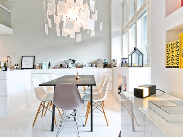 Niska nowoczesna zabudowa szafek kuchennych w nowoczesnej aranżacji z czarnym stołem i krzesłami VITRA w jadalni (25374)
