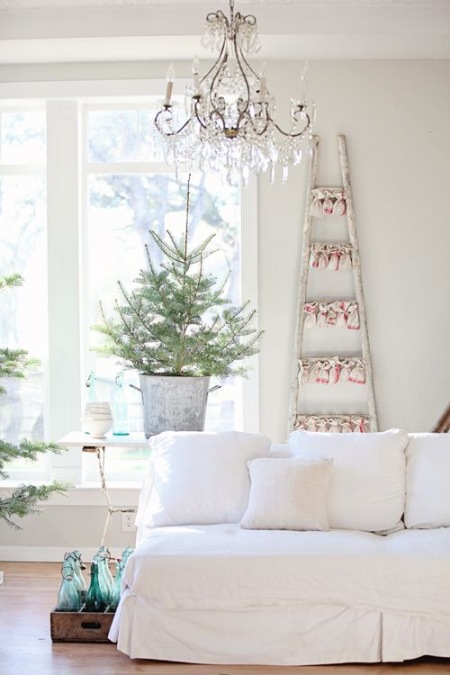 Drewniana biała drabina w światecznej dekoracji w salonie z choinką w ocynkowanym wiadrze