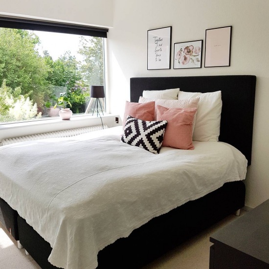 Czarne łóżka i różowe dodatki w sypialni