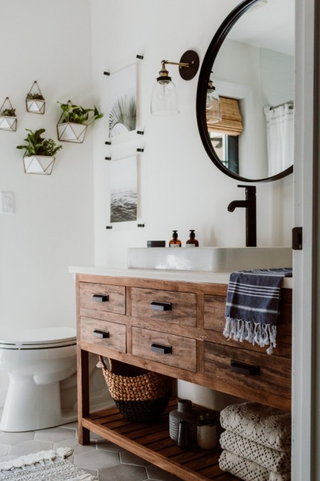 Aranżacja łazienki z piękną drewnianą szafką pod umywalką