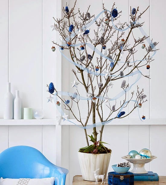 Szafirowe szyszki na zdrewniałym drzewku z niebieskimi tasiemkami,niebieskie krzesło i dodatki w białej jadalni