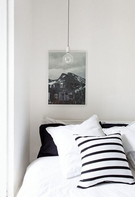 Żarówka na kablu w sypialni skandynawskiej w biało-czarnych kolorach