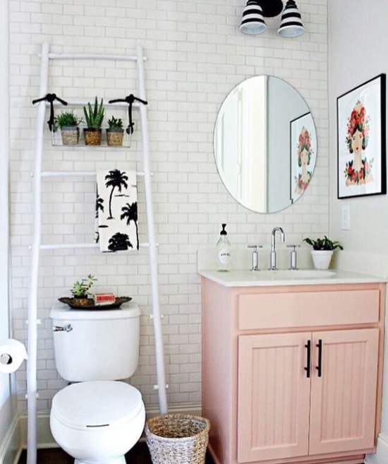 Biała drabina i różowa szafka w małej łazience