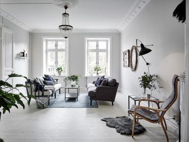 Białe sztukaterie przy suficie,kryształowy żyrandol,stylowa szara sofa,drewniana kanapa w stylu skandynawskim,stylowe ramy  na obrazy (47750)