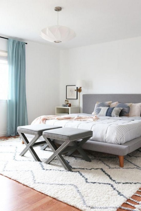 Sypialnia w minimalistycznym stylu z szarym łóżkiem