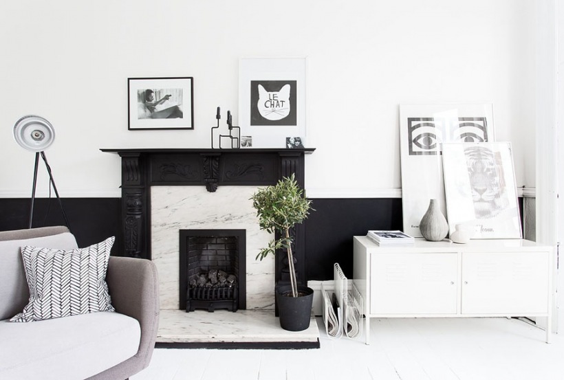 Kominek z bialego marmuru w czarnej stylowej obudowie w skandynawskim salonie