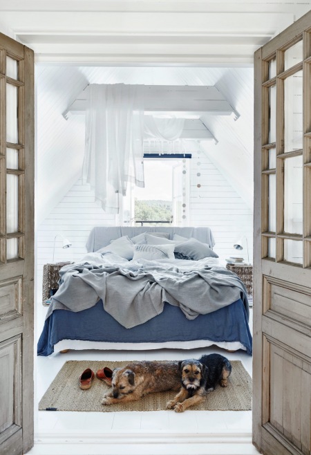 Bielone drewniane belki z romantycznym upięciem białych firan-baldachimu w aranżacji sypialni z niebieska dekoracją łóżka