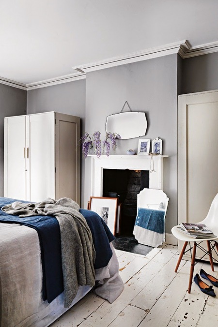 Szare ściany i biała podłoga vintage w sypialni z ciemnoniebieskimi dodatkami