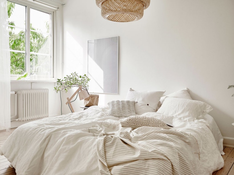 Biała sypialnia z wiklinową lampą