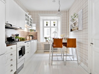 Aranżacja białej kuchni z tapetą w kratkę i drewnianym krzesłami na metalowych nogach (21824)