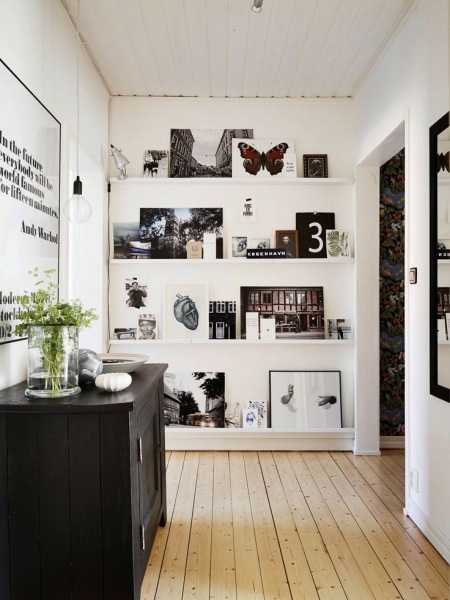 Wąskie białe półki na ścianie,czarno-białe fotografie i grafiki nowoczesne,czarna komoda,plakat Warhola