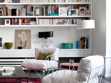 Różowy dywan vintage,biały nowoczesny fotel z metalowych pretów i z poduchami,białe półki na ścianie w salonie (26183)