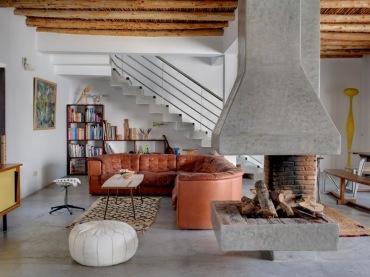 oryginalny pomysł na betonowy kominek na środku salon - to marokański salon w nowoczesnym wydaniu.