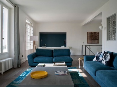 Turkusowe nowoczesne sofy,turkusowy dywan vintage w otwartym białym salonie  nowoczesną kuchnią (24970)