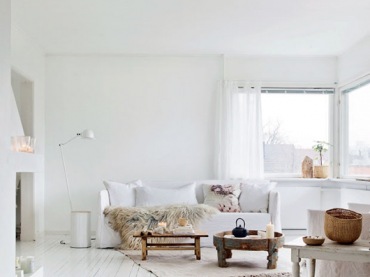 Białe malowane deski na podłodze w salonie,białe sofy,drewniane stoliki i ławy w stylu skandynawskim,futrzaki,lampa podłogowa biała z wysięgnikiem (47900)