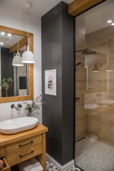 Aranżacja łazienki z czarną ścianką i drewnianymi dodatkami