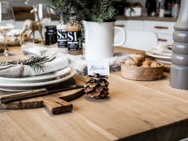 Na stole stoi sporo drewnianych dodatków, które z wdziękiem nawiązują do blatu. Podkreślają też prostotę i naturalność świątecznej...