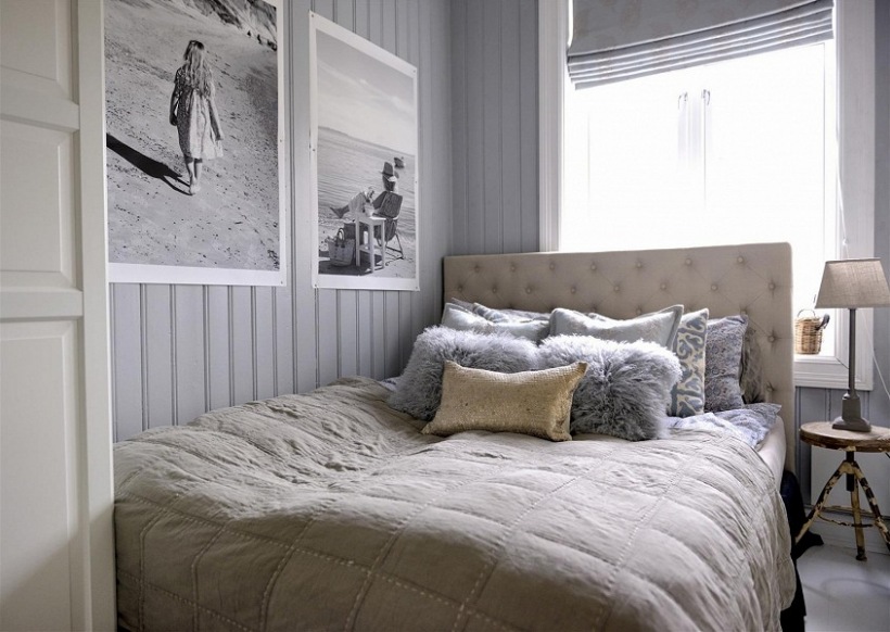Pikowane łóżko,czarno-białe fotografie,futerkowe poduszki i industrialny stołek przy łóżku