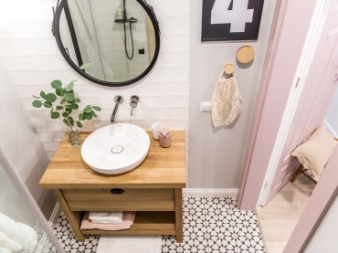 Mała łazienka jest nie tylko urządzona funkcjonalnie, ale też estetycznie. Różowe drzwi pasują do delikatnego wystroju, a czarne elementy ożywiają...