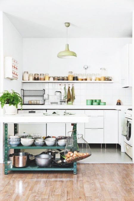 Modern rustic styl w białej kuchni z metalową wyspą kuchenną z półkami i zielonymi dodatkami
