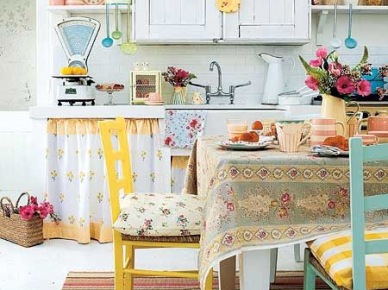Wiejska kuchnia z żółtymi i turkusowymi krzesłami,tkanymi kolorowymi dywanikami w paski,kwiecistym obrusem i dodatkami z emaliowanej blachy (26603)