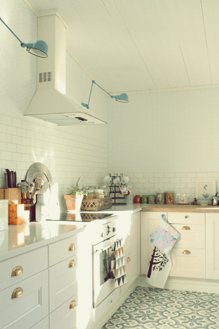 Turkusowe kinkiety na białej ścianie w kuchni