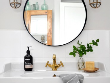 Okrągłe lustro nad umywalką wprowadza pewną harmonię do wnętrza. Łazienka, pomimo swojego oryginalnego charakteru, prezentuje się bardzo spokojnie i schludnie....