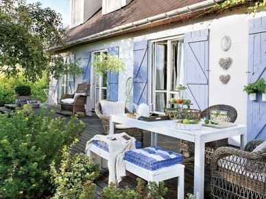 Niebieskie okiennice w białym domku  z pięknym drewnianym tarasem (21286)