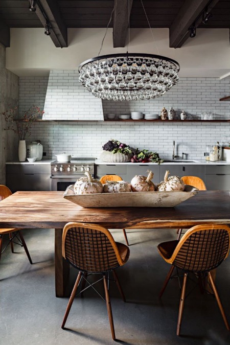 Biała cegła, drewniany stół i kryształowy żyrandol w kuchni