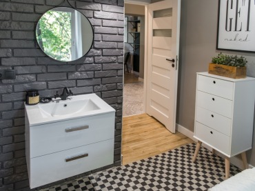 Dobrane kolory bieli, szarości i czerni dodają łazience eleganckiego charakteru. Jednym z ciekawszych rozwiązań jest podłoga z geometrycznym...