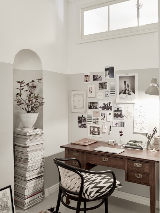 Klasyczne brązowe biurko,gięte drewniane krzesło,galeria grafik i czarno-białych fotografii na białej ścianie w domowym biurze