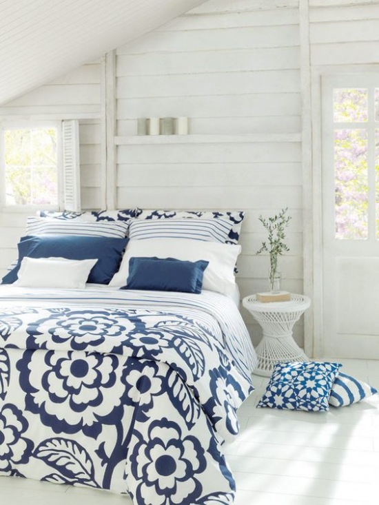 Biała sypialnia na poddaszu z drewnianą podłogą i ścianami z desek