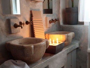 Klimatyczna aranżacja łazienki w kamieniu, którą podkreślają zastosowane dekoracje. Zapalone po zmroku świece wydobywają piękno naturalnego materiału. Dwie umywalki w łazience stanowią wygodne rozwiązanie dla...