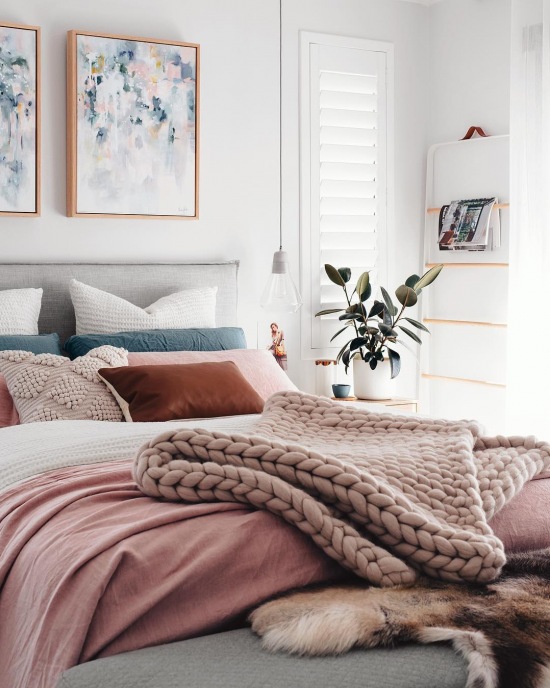 Różowe dodatki do szarej sypialni w skandynawskim stylu