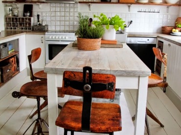 Industrialne krzesła w stylu vintage w aranżacj białej kuchni z drewnianymi pólkami i białym postarzanym stołem (24824)
