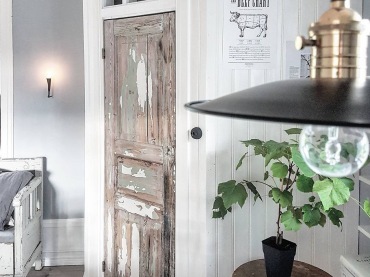 Przetarte drzwi kojarzą się ze stylem rustykalnym, który konsekwentnie podkreślają białe panele ścienne czy drewniane...