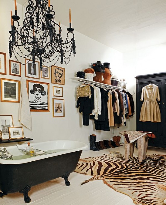 Łazienka z garderobą z czarną wanną na łapkach i skórzanym dywanem zebry
