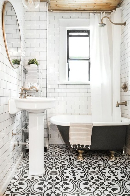 Biała łazienka z czarną wanną i wzorzystą podłogą