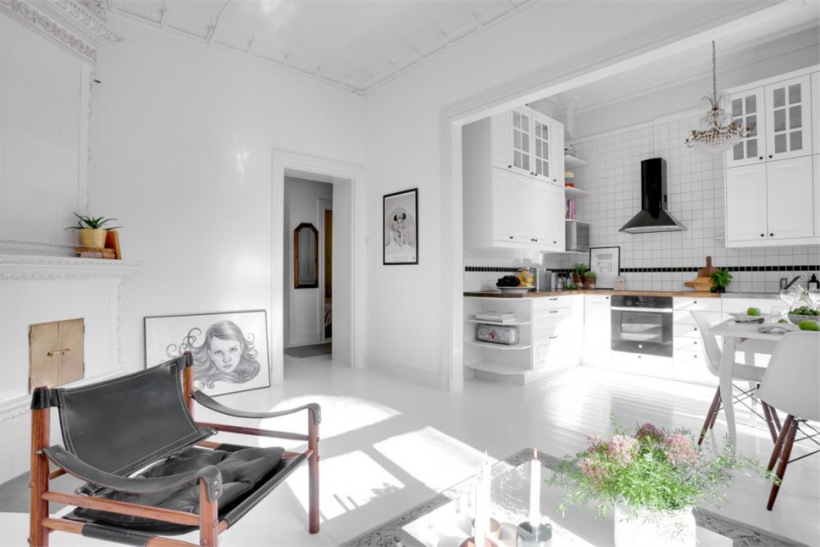 Biały salon z kuchnią w otwartej zabudowie mieszkania