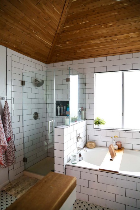 Drewniany skośny sufit w łazience z wanną i prysznicem