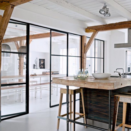 Przeszklona ścianka działowa w metalowych czarnych ramach pomiędzy salonem i kuchnią,drewniane belki