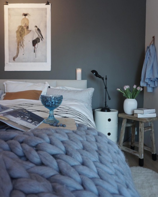 Błękitne dodatki i białe meble w szarej sypialni