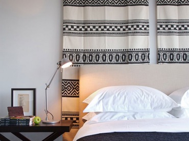 Etniczny czarno-biały kilim nad łóżkiem w biało-czarnej sypialni (20892)