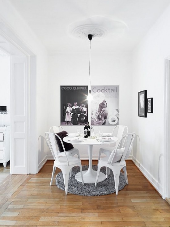 Plakaty i okrągły stół w małej jadalni w biało-czarnym kolorze