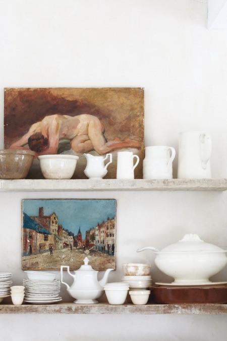 Kamienne półki ozdobione porcelaną i klasycznymi obrazami w jadalni