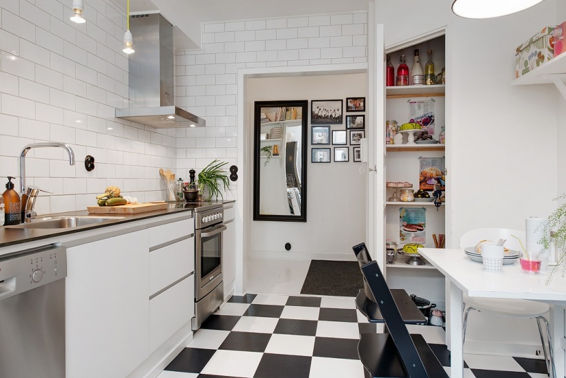 Biało-czarna posadzka w szachownicę,biała płytka cegiełka na ścianie i biało-czarne meble w skandynawskiej kuchni