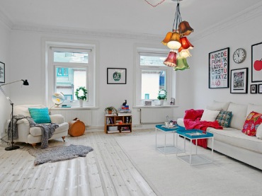 Aranżacja skandynawskiegobiałego salonu z kolorowymi poduszkami i lampą (22027)